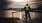 person standing on a bridge overlooking water