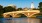 a bridge over a body of a water with some one in a kayak